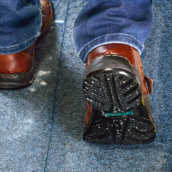 SaniStride customer adds shoe sanitizer to shoe disinfecting mat diminishing the spread of germs